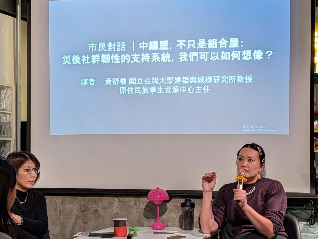 一場討論市民對話的活動，主題為「災後社群性的支持系統，我們可以如何想像」。左側一位女性参与者正在聆聽右側女性講者發言，講者的名字和背景在螢幕上顯示。