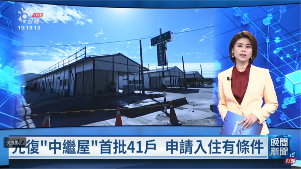 一位女性新聞主播在報導中，背景是工地上搭建的臨時住房，現場有圍欄和交通標誌，呈現出藍天和白雲的景象。